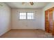 Bedroom featuring carpet, neutral walls, a window, and wood door at 5830 W Nc 10 Hwy, Hickory, NC 28602