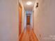 Hallway with hardwood flooring, neutral walls, and doors leading to various rooms at 5830 W Nc 10 Hwy, Hickory, NC 28602