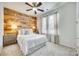 Charming bedroom features a wooden accent wall, ceiling fan, and bright natural light from the window at 663 Sixth Baxter Xing, Fort Mill, SC 29708