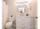 Bathroom featuring a modern vanity with marble countertop, round mirror, and silver hardware at 7101 Quail Meadow Ln, Charlotte, NC 28210