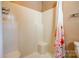 The bright shower showcases white tile, a built-in bench, and a colorful floral shower curtain at 723 W Zion Church Rd, Shelby, NC 28150