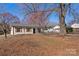 Single-story home featuring brick facade, wooden shutters, and a big front yard with a few trees at 8009 Idlewild Rd, Indian Trail, NC 28079