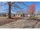 Single-story home featuring brick facade, wooden shutters, and a spacious front yard with trees at 8009 Idlewild Rd, Indian Trail, NC 28079