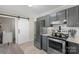 Well designed kitchen with gray cabinets, stainless steel appliances, granite counters, and a barn-style door at 8009 Idlewild Rd, Indian Trail, NC 28079