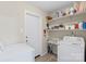 Functional laundry room with modern appliances and lots of shelves, maximizing storage and convenience at 8009 Idlewild Rd, Indian Trail, NC 28079