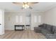 Bright living room with neutral walls, modern ceiling fan, and grey couch at 8009 Idlewild Rd, Indian Trail, NC 28079