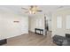 Bright living room with neutral walls, modern ceiling fan, a grey couch, and an open door at 8009 Idlewild Rd, Indian Trail, NC 28079