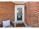 Charming brick entryway featuring a decorative glass storm door and a cozy welcome mat at 8328 Highland Glen Dr, Charlotte, NC 28269