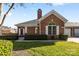 Quaint brick home with manicured lawn, attached garage, and charming architectural details at 8328 Highland Glen Dr, Charlotte, NC 28269