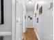 Clean hallway with neutral paint, lighting, doors, and wood floors, creating a seamless transition at 8328 Highland Glen Dr, Charlotte, NC 28269