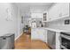 Bright kitchen open to the living room with white cabinets and stainless steel appliances at 8328 Highland Glen Dr, Charlotte, NC 28269