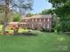 Spacious brick home with red shutters, well-manicured lawn, and beautiful landscaping at 8432 Junction Ct, Charlotte, NC 28215