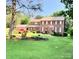 Spacious brick home with red shutters, well-manicured lawn, and beautiful landscaping at 8432 Junction Ct, Charlotte, NC 28215