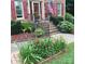 Charming brick home featuring a lovely front porch adorned with colorful flowers and an American flag at 8432 Junction Ct, Charlotte, NC 28215