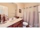 A cozy bathroom featuring a cherry-wood vanity, cream walls, and a framed mirror at 8436 Summerford Dr, Charlotte, NC 28269