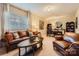 Spacious living room showcasing a large window, leather furniture, and a decorative round mirror at 8436 Summerford Dr, Charlotte, NC 28269