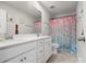 Bathroom with double vanity, white cabinets and colorful mermaid shower curtain at 925 Deep River Way, Waxhaw, NC 28173