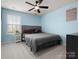 Relaxing bedroom with a window view, ceiling fan, and sports decor, creating a comfortable space at 925 Deep River Way, Waxhaw, NC 28173