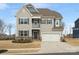 Charming two-story home featuring a welcoming porch, two-car garage, and manicured front yard at 925 Deep River Way, Waxhaw, NC 28173