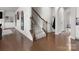 View of a bright hallway with hard wood flooring and a staircase with a wooden handrail at 925 Deep River Way, Waxhaw, NC 28173