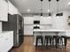 Spacious kitchen featuring stainless steel appliances, a large island, and sleek white cabinetry at 925 Deep River Way, Waxhaw, NC 28173