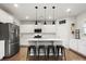 Bright kitchen features white cabinets, stainless steel appliances, and a large island with barstool seating at 925 Deep River Way, Waxhaw, NC 28173