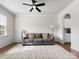 Cozy living room featuring a ceiling fan, gray sofa, large rug, and wainscoting at 925 Deep River Way, Waxhaw, NC 28173