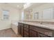 Bathroom featuring dual sinks, granite counters, dark wood cabinets, and a soaking tub at 966 Parkland Nw Pl, Concord, NC 28027