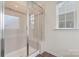 Tiled bathroom featuring a glass enclosed shower with bench and a window at 966 Parkland Nw Pl, Concord, NC 28027