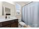 This bathroom features a vanity with dark wood cabinets, a toilet, and a shower with a curtain at 966 Parkland Nw Pl, Concord, NC 28027