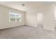 Bright, carpeted bedroom featuring a window for natural light and an open doorway at 966 Parkland Nw Pl, Concord, NC 28027