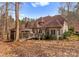 A beautiful backyard view showcasing a house with a deck and screened-in gazebo, surrounded by fall foliage and lush trees at 109 Hawksnest Ln, Mooresville, NC 28117