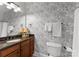 Cozy half bathroom featuring floral wallpaper, a granite countertop, and a wood vanity at 109 Hawksnest Ln, Mooresville, NC 28117