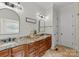 Bathroom with double vanity, granite countertop, framed mirrors, and wood cabinets at 109 Hawksnest Ln, Mooresville, NC 28117