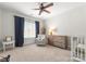 Well-lit bedroom with a crib, wooden dresser, and comfortable chair by a window at 109 Hawksnest Ln, Mooresville, NC 28117