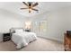 Bright bedroom with neutral carpet, a ceiling fan, and large window allowing for natural light at 109 Hawksnest Ln, Mooresville, NC 28117