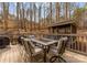 A spacious outdoor deck features an outdoor dining table with chairs for entertainment, overlooking a serene wooded landscape at 109 Hawksnest Ln, Mooresville, NC 28117