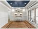 Elegant dining room with a modern chandelier, wainscoting, large window, and hardwood floors with decorative borders at 109 Hawksnest Ln, Mooresville, NC 28117