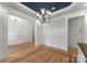 A formal dining room with an elegant chandelier, wainscoting, hardwood floors, and neutral paint tones at 109 Hawksnest Ln, Mooresville, NC 28117