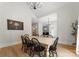 Bright dining room featuring hardwood floors, modern lighting, a large table and access to the living room at 109 Hawksnest Ln, Mooresville, NC 28117