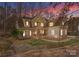 A beautiful two story home featuring a stone facade, siding, and manicured lawn highlighted by a colorful sunset at 109 Hawksnest Ln, Mooresville, NC 28117