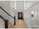 Bright foyer with hardwood floors, grand staircase, soaring ceilings, transom window and an impressive wooden front door at 109 Hawksnest Ln, Mooresville, NC 28117
