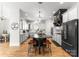 Modern kitchen with white cabinets, black appliances, an island with seating, and hardwood floors at 109 Hawksnest Ln, Mooresville, NC 28117
