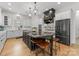 Modern kitchen featuring white cabinets, black appliances, an island with seating, and hardwood floors at 109 Hawksnest Ln, Mooresville, NC 28117