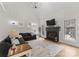 Bright living room with a black fireplace, mantle TV, large sectional, windows and hardwood floors at 109 Hawksnest Ln, Mooresville, NC 28117