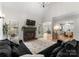 Bright living room with a black fireplace, mantle TV, large sectional and access to the dining room and kitchen at 109 Hawksnest Ln, Mooresville, NC 28117