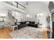 Bright living room with a black fireplace, large sectional, hardwood floors and access to a staircase at 109 Hawksnest Ln, Mooresville, NC 28117