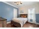 Cozy bedroom with a wooden bed frame, hardwood floors, and a large window at 12726 Rusty Blackbird Way, Charlotte, NC 28278
