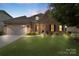 Charming brick home features a manicured lawn, attached garage, and inviting front entrance with manicured landscaping at 12726 Rusty Blackbird Way, Charlotte, NC 28278