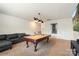 Bright game room boasts a pool table, leather sofa, and entertainment setup at 12726 Rusty Blackbird Way, Charlotte, NC 28278
